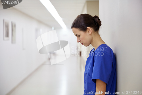 Image of sad female nurse at hospital corridor