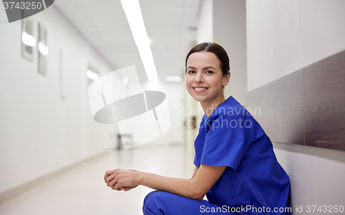 Image of smiling female nurse at hospital corridor