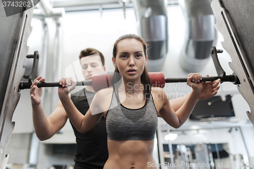 Image of man and woman with barbell flexing muscles in gym