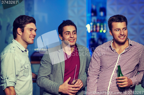 Image of group of male friends with beer in nightclub