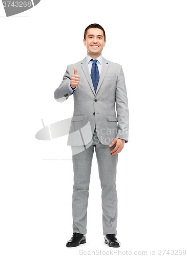 Image of happy businessman in suit showing thumbs up