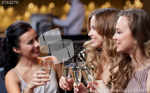 Image of happy women with champagne glasses at night club