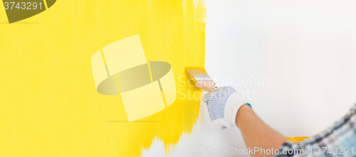 Image of close up of male in gloves painting a wall