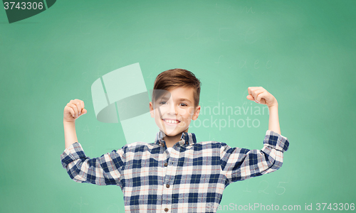 Image of happy boy in checkered shirt showing strong fists