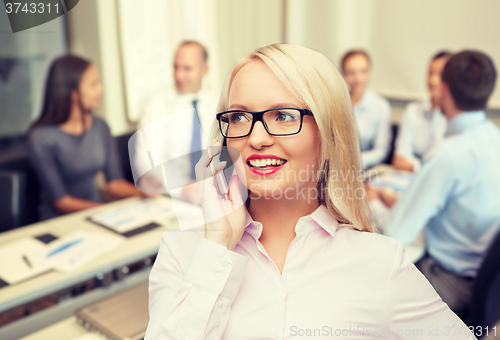 Image of smiling businesswoman calling on smartphone