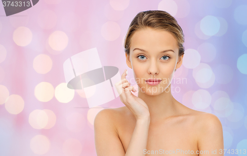 Image of young woman applying cream to her face