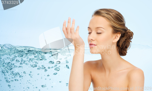 Image of woman smelling perfume from wrist of her hand