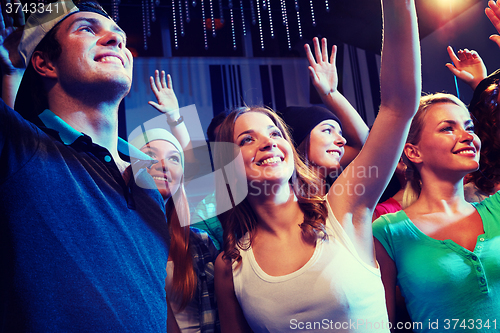 Image of smiling friends at concert in club