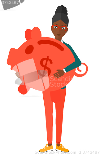 Image of Woman carrying piggy bank.