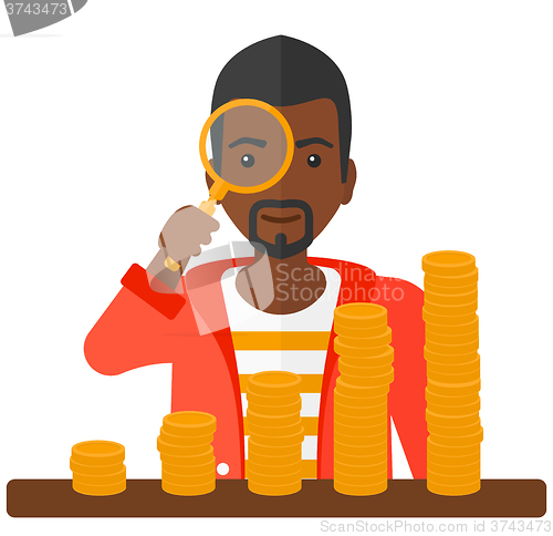 Image of Man with magnifier and golden coins. 