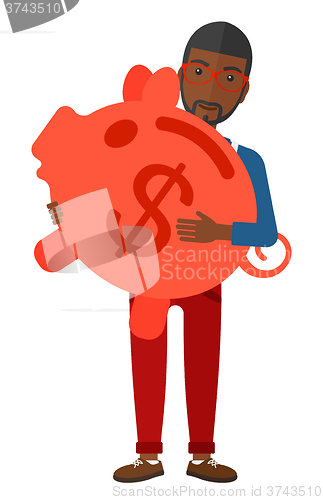 Image of Man carrying piggy bank.