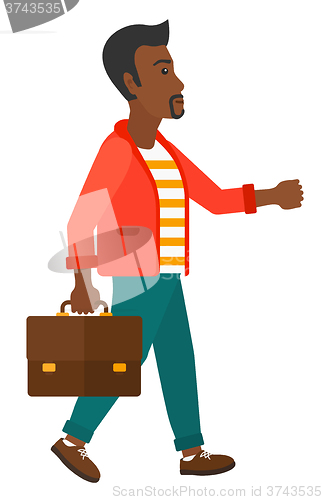 Image of Businessman walking with briefcase. 