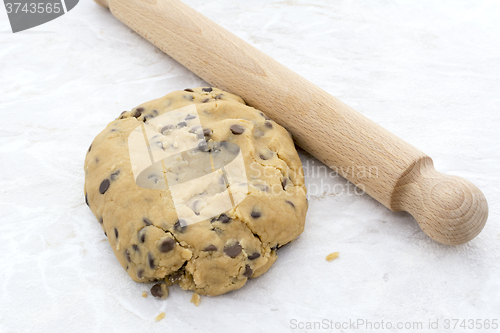 Image of Chocolate chip cookie dough with a rolling pin