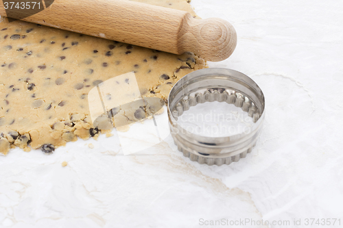 Image of Cookie cutter with cookie dough and rolling pin