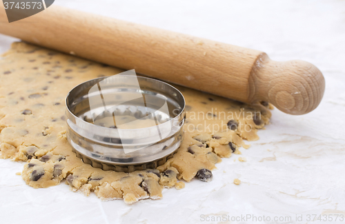 Image of Cookie cutter and rolling pin on cookie dough