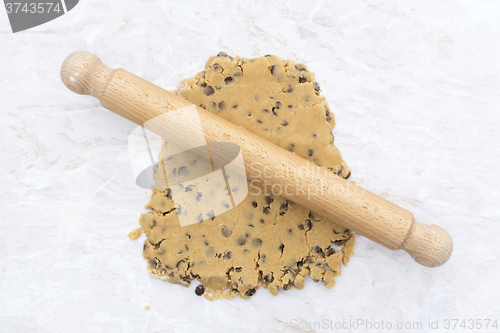 Image of Cookie dough being rolled out with a wooden rolling pin