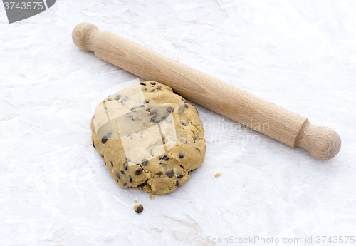 Image of Ball of chocolate chip cookie dough with rolling pin