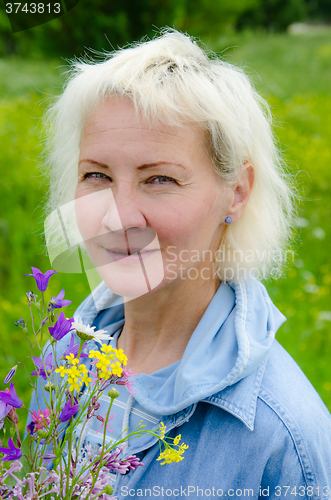 Image of Portrait of woman with a bouquet of wildflowers in your hand