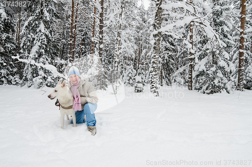 Image of The woman with a dog on walk in a winter wood