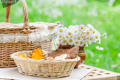 Image of Buns in a wicker basket and a bouquet of flowers