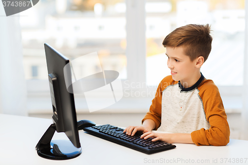 Image of smiling boy with computer at home