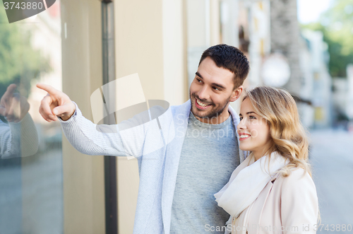 Image of happy couple shopping and looking at shop window