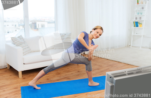 Image of woman making yoga low angle lunge pose on mat