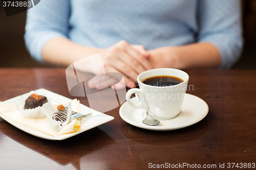 Image of close up of woman hands with coffee and dessert