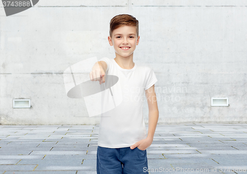 Image of happy boy in white t-shirt pointing finger to you