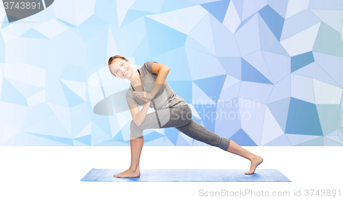 Image of woman making yoga low angle lunge pose on mat