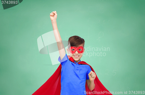 Image of boy in red superhero cape and mask showing fists