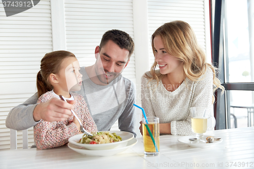 Image of happy family having dinner at restaurant or cafe