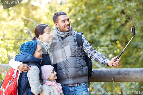 Image of happy family with smartphone selfie stick in woods