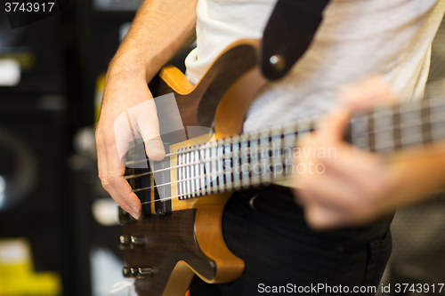 Image of close up of musician with guitar at music studio