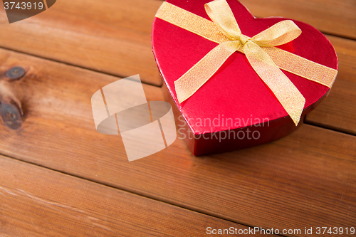 Image of close up of heart shaped gift box on wood