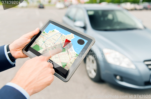 Image of close up of hands with gps on tablet pc and car