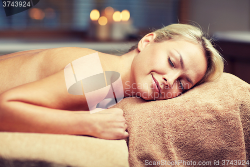 Image of young woman lying on massage table in spa