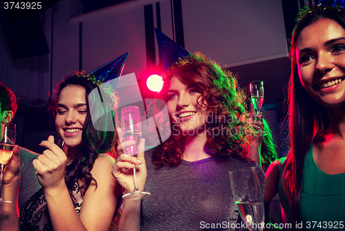 Image of smiling friends with glasses of champagne in club