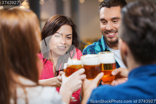 Image of friends drinking beer and clinking glasses at pub