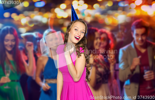 Image of happy woman or teen in party cap at night club