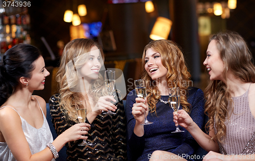 Image of happy women with champagne glasses at night club