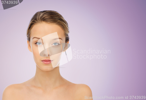 Image of young woman face with bare shoulders over violet