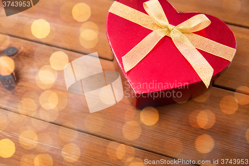 Image of close up of heart shaped gift box on wood