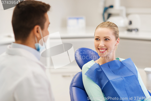 Image of happy male dentist with woman patient at clinic