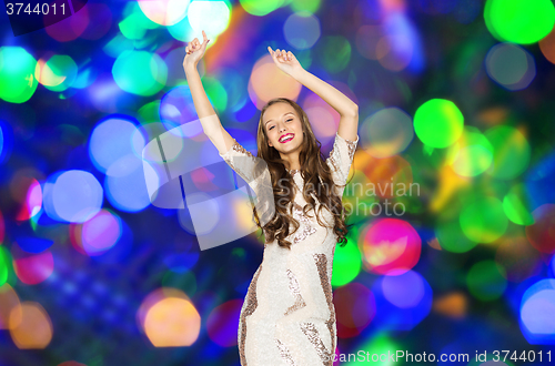 Image of happy young woman dancing over disco lights