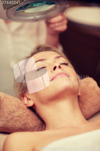Image of close up of young woman lying in spa