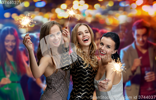 Image of happy young women with sparklers at night club