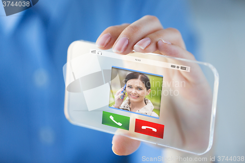 Image of close up of hand with incoming call on smartphone