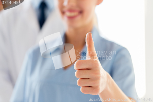 Image of close up of doctor or nurse showing thumbs 