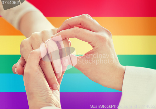 Image of close up of lesbian couple hands with wedding ring